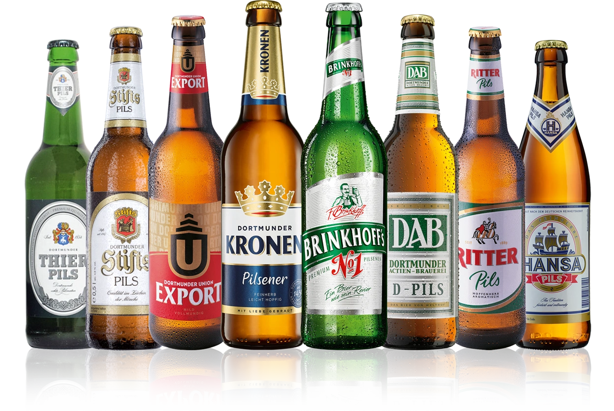 Verschiedene Bierflaschen stehen nebeneinander auf einer Oberfläche. Jede Flasche trägt ein individuelles Etikett.